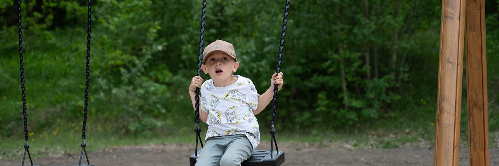 Boy on a swing with a wooden frame.